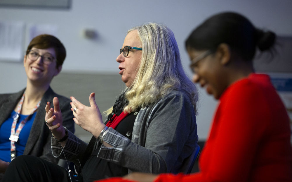 Katherine Dalke and Yendelela Cuffee sit on both sides of Pennsylvania Health Secretary Dr. Rachel Levine. Levine gestures and both Dalke and Cuffee smile and laugh in response.