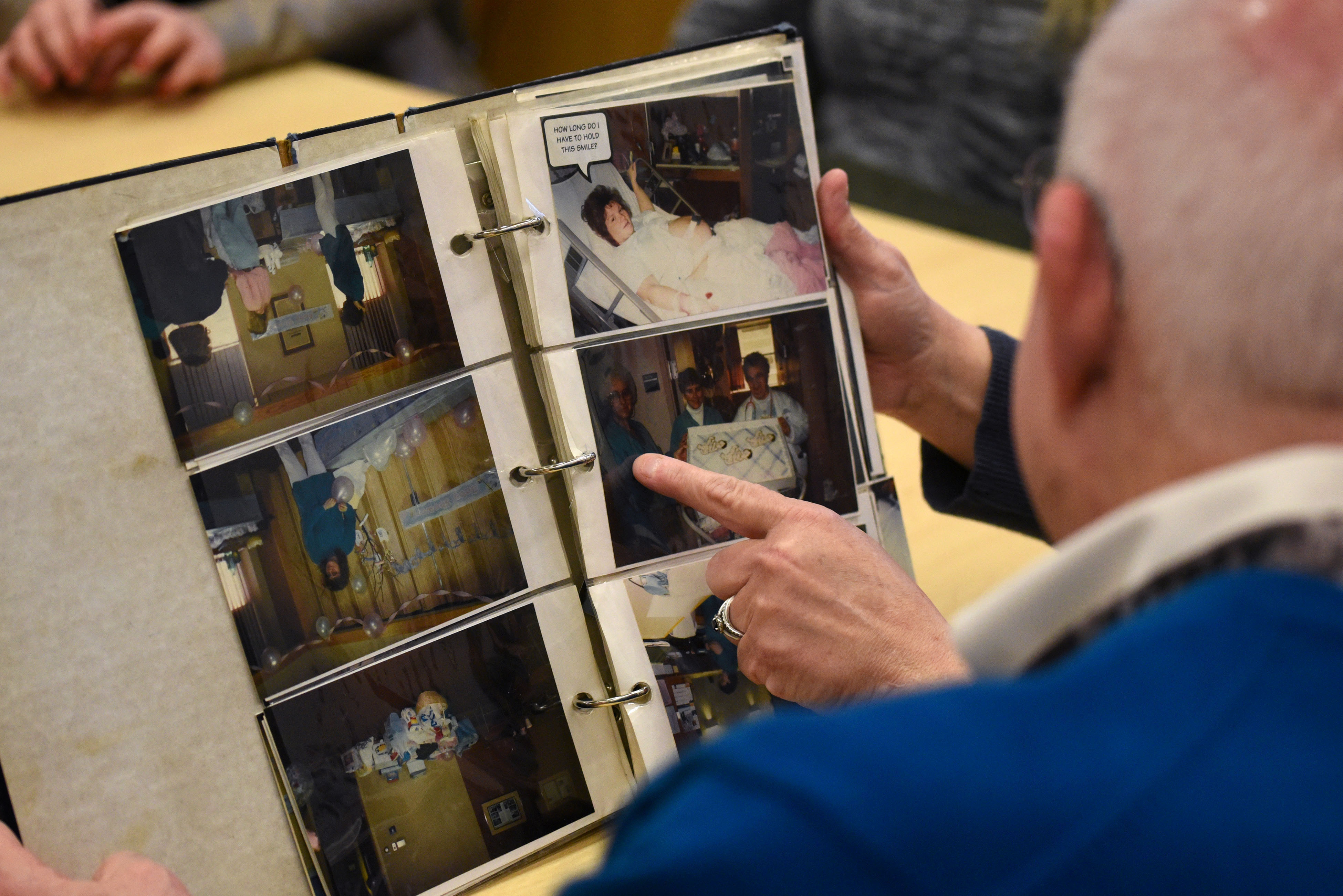 Janet Boyer looks at photo albums with Dr. Anthony Ambrose, FACOG, at Penn State Health Milton S. Hershey Medical Center on Feb. 29, 2020. Boyer is the mom of Beth Ann, Mackenzie and Emily Schneck, leap year triplets born at the hospital on Feb. 29, 1996. They came back on their “sixth” birthday to tour the new children’s hospital expansion.