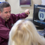A doctor talks with patient while looking at an image of lungs