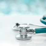 A close-up of a stethoscope sitting on a desk.