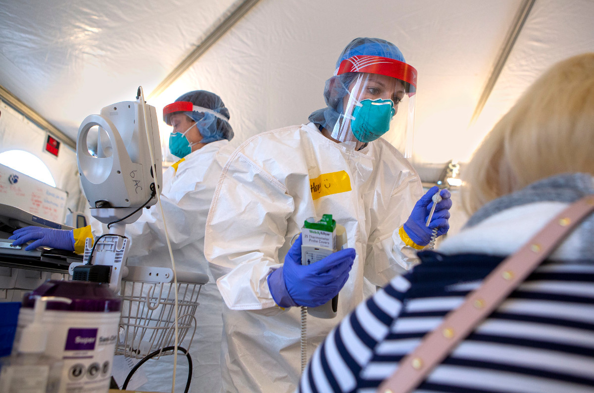 Image shows a healthcare worker in protective gear treating a patient