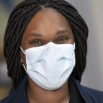 Shalana Key, a supply technician at Hershey Medical Center, wears a Level 1 face mask. She has braids and is smiling under her mask.
