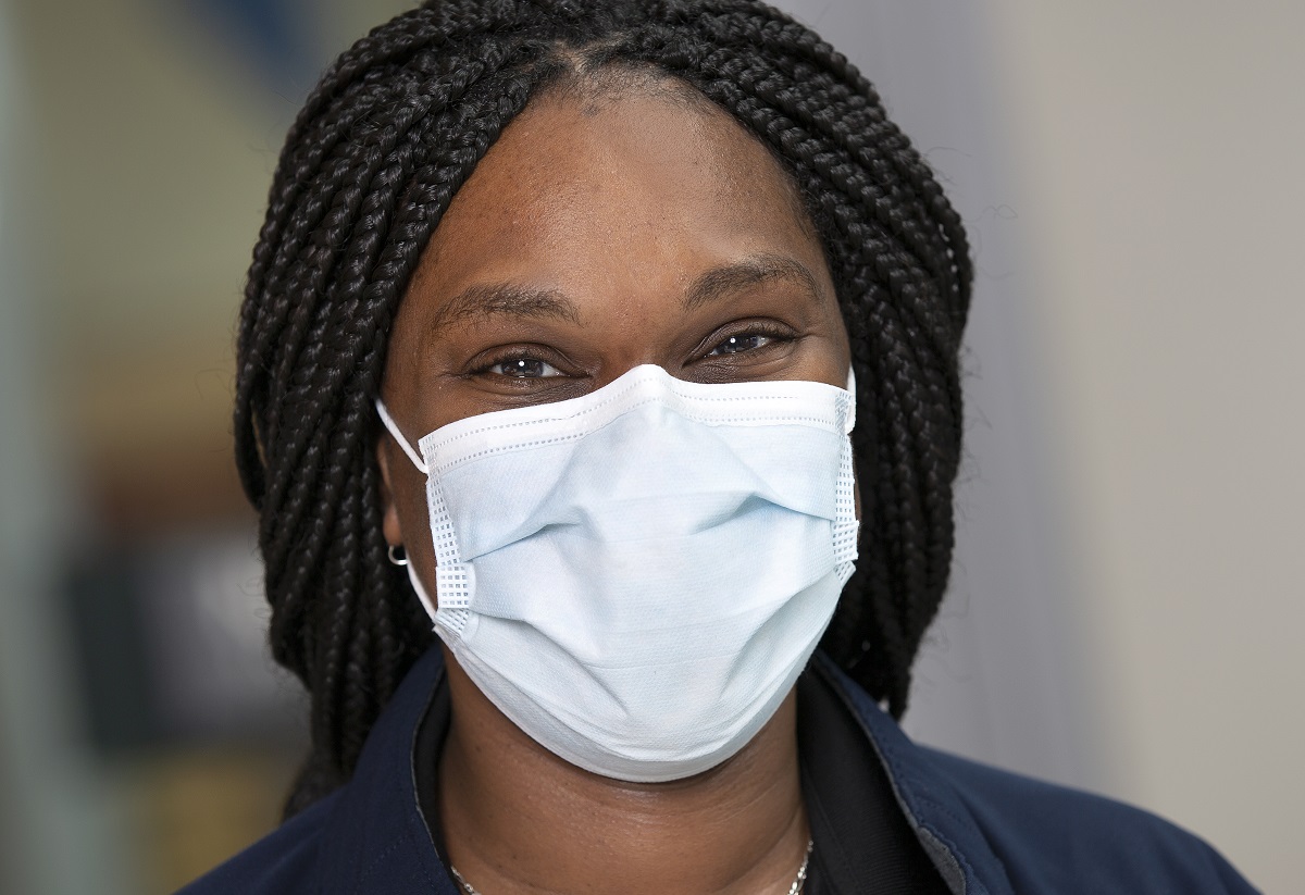 Shalana Key, a supply technician at Hershey Medical Center, wears a Level 1 face mask. She has braids and is smiling under her mask.