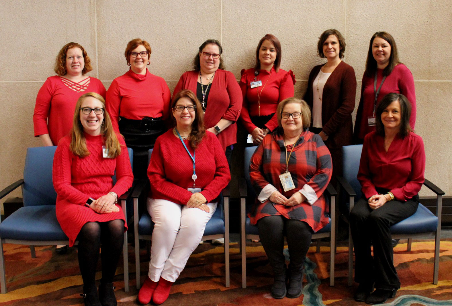 A group of 10 women is seen wearing various shades of red.