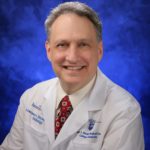 Dr. Lawrence Sinoway, cardiologist and director, Penn State Heart and Vascular Institute, wearing cream-colored dress shirt, red tie and white Penn State Health Milton S. Hershey Medical Center lab coat.