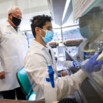 Two men in doctors' coats work in a research lab