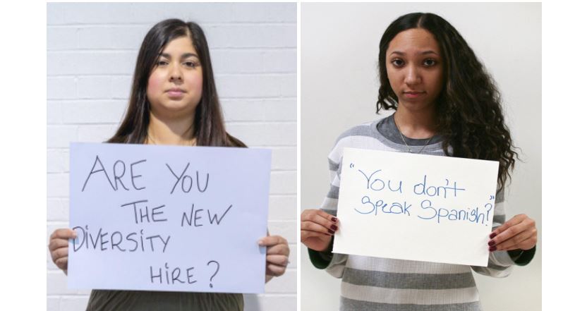 Two women hold signs with messages to new hires about diversity. 