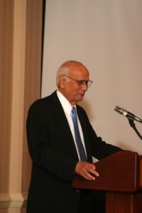 Dr. Satvir Tevethia stands at a podium and speaks during a research symposium.