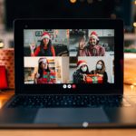 A laptop features several people having a virtual holiday party.