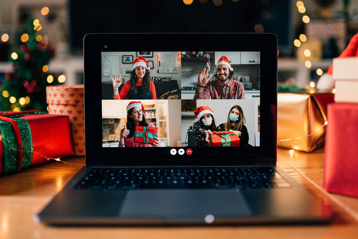 A laptop features several people having a virtual holiday party.