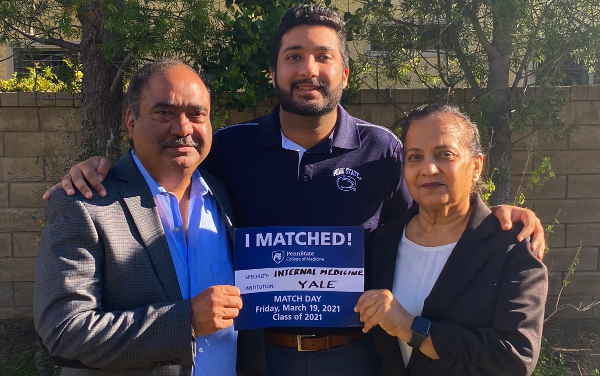 Arshjot Khokhar, a fourth-year medical student at Penn State College of Medicine, stands with his parents holding a sign saying that he matched into internal medicine residency at Yale New Haven Hospital.