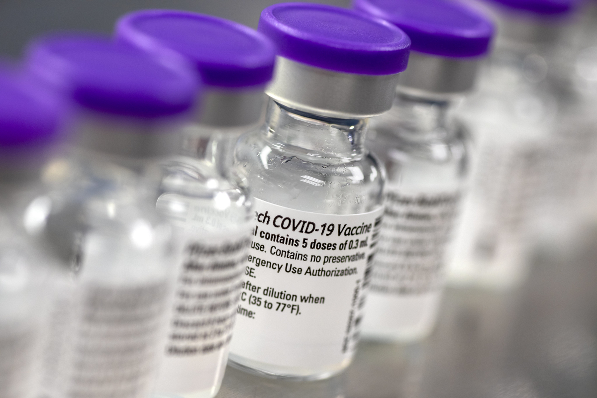 A close-up of several small bottles of COVID-19 vaccine, side by side.