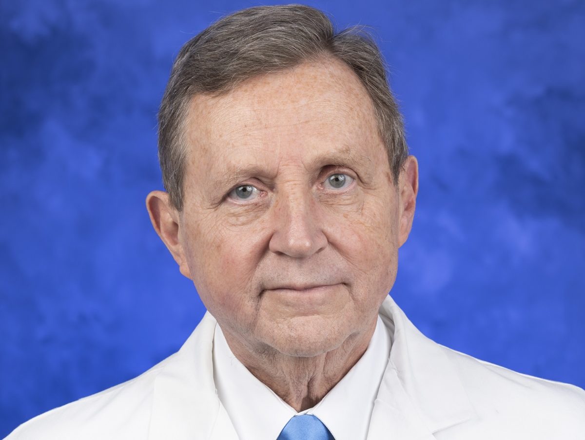 Dr. Robert Harbaugh with Penn State Health Milton S. Hershey Medical Center is pictured in a head-and-shoulders professional headshot. He is wearing a dress shirt, tie and lab coat embroidered with the Penn State logo.