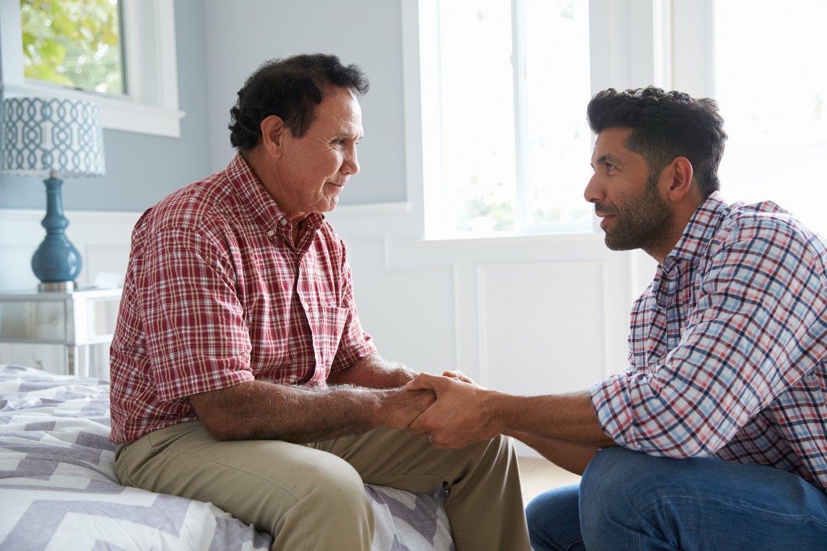 An adult son has a conversation about end-of-life care with his aging father.