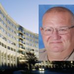 Head shot of a man wearing glasses and a tan uniform.