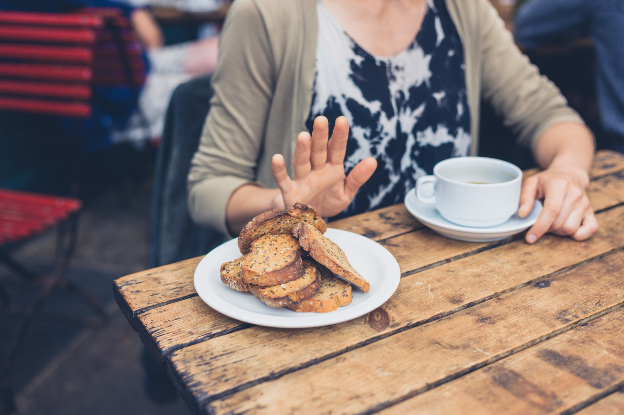 Woman on gluten free diet is saying no thanks to toast in a café.