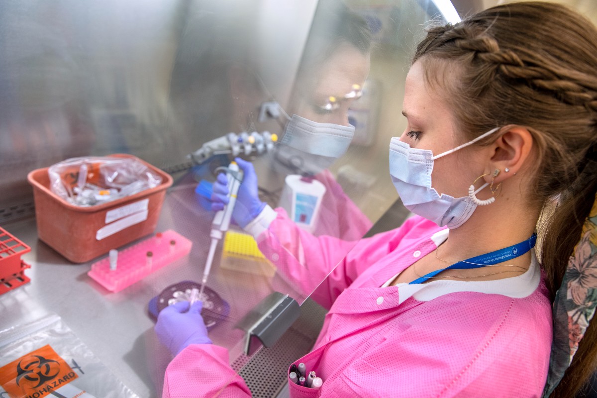 Ashlee Ramirez, a medical laboratory scientist with Penn State Health Milton S. Hershey Medical Center, tests a patient's specimen in a virology lab.