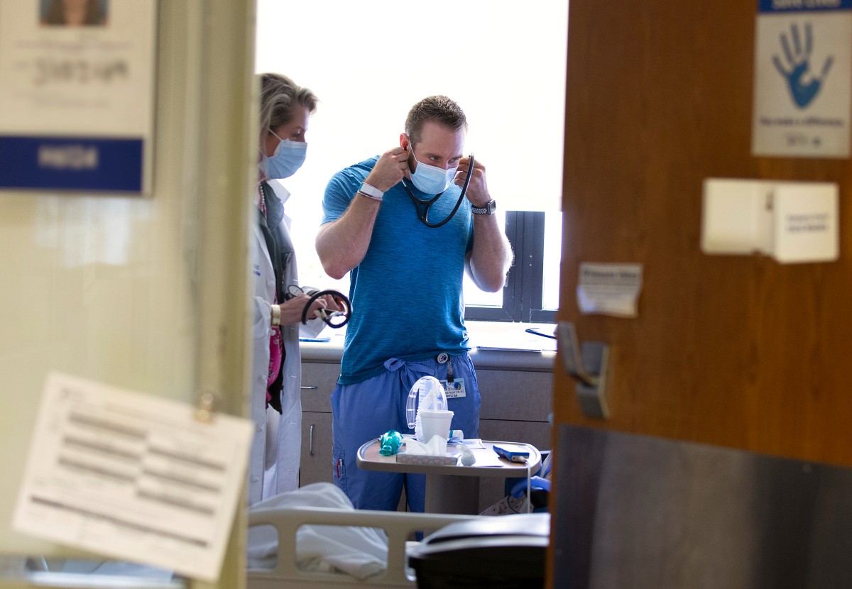Two doctors stand in a patient room at Penn State Health Milton S. Hershey Medical Center.