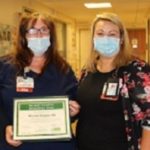 Left photo: A man wearing nursing scrubs and a face mask receives a plaque from a woman wearing a face mask and eyeglasses. Right photo: A woman wearing nursing scrubs, eyeglasses and a face mask receives a plaque from a woman wearing a face mask.