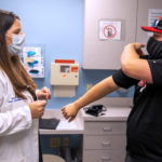 A doctor discusses injuries with a patient in an exam room.