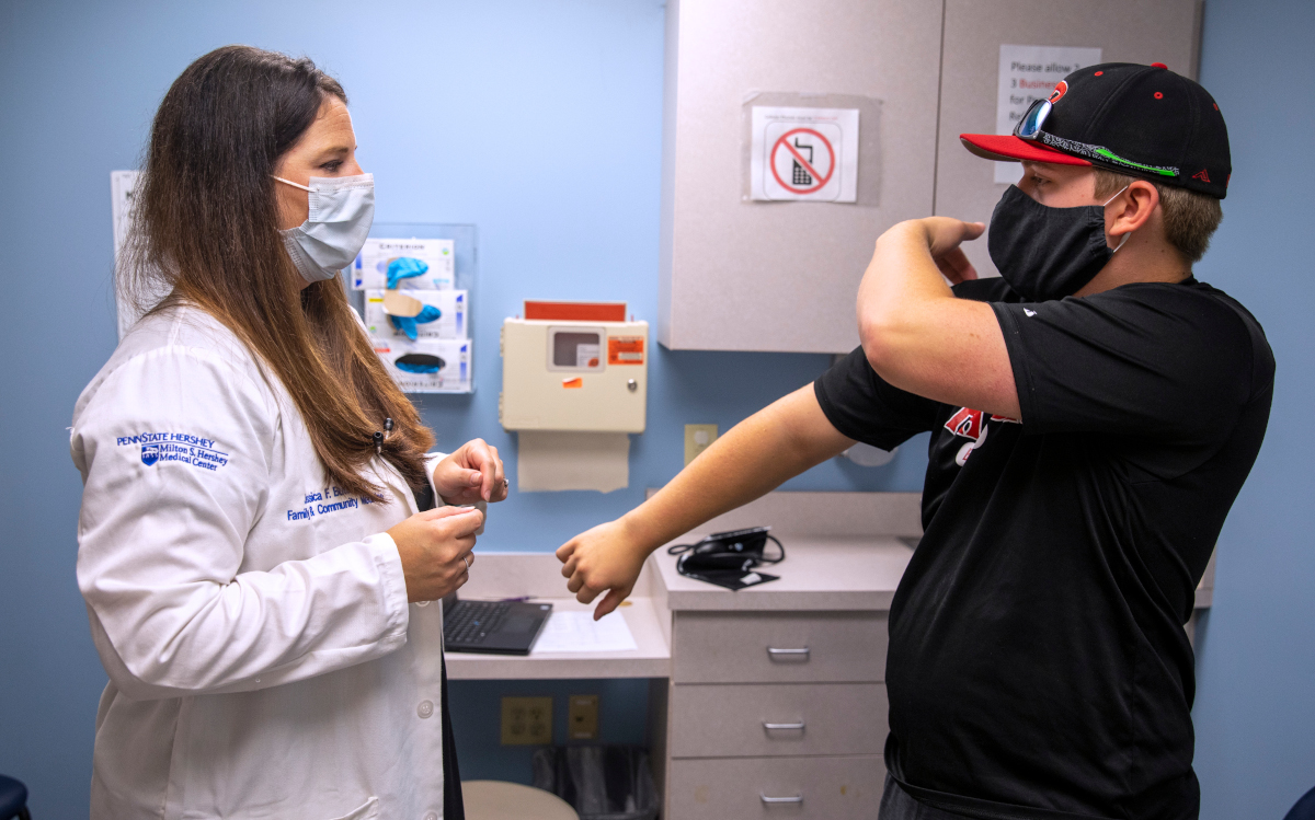 A doctor discusses injuries with a patient in an exam room.