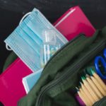 Backpack prepared with study supplies and mask for the return to school.