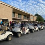 Golf carts are pictured outdoors on a golf course