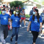 Three people in Penn State Health t-shirts walk down a street in Harrisburg during a Heart Walk event.