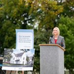 Dr. Jennifer Kraschnewski delivers a speech while standing at a podium at the groundbreaking ceremony for the first home being built as part of the Got Your 6 at Home initiative.