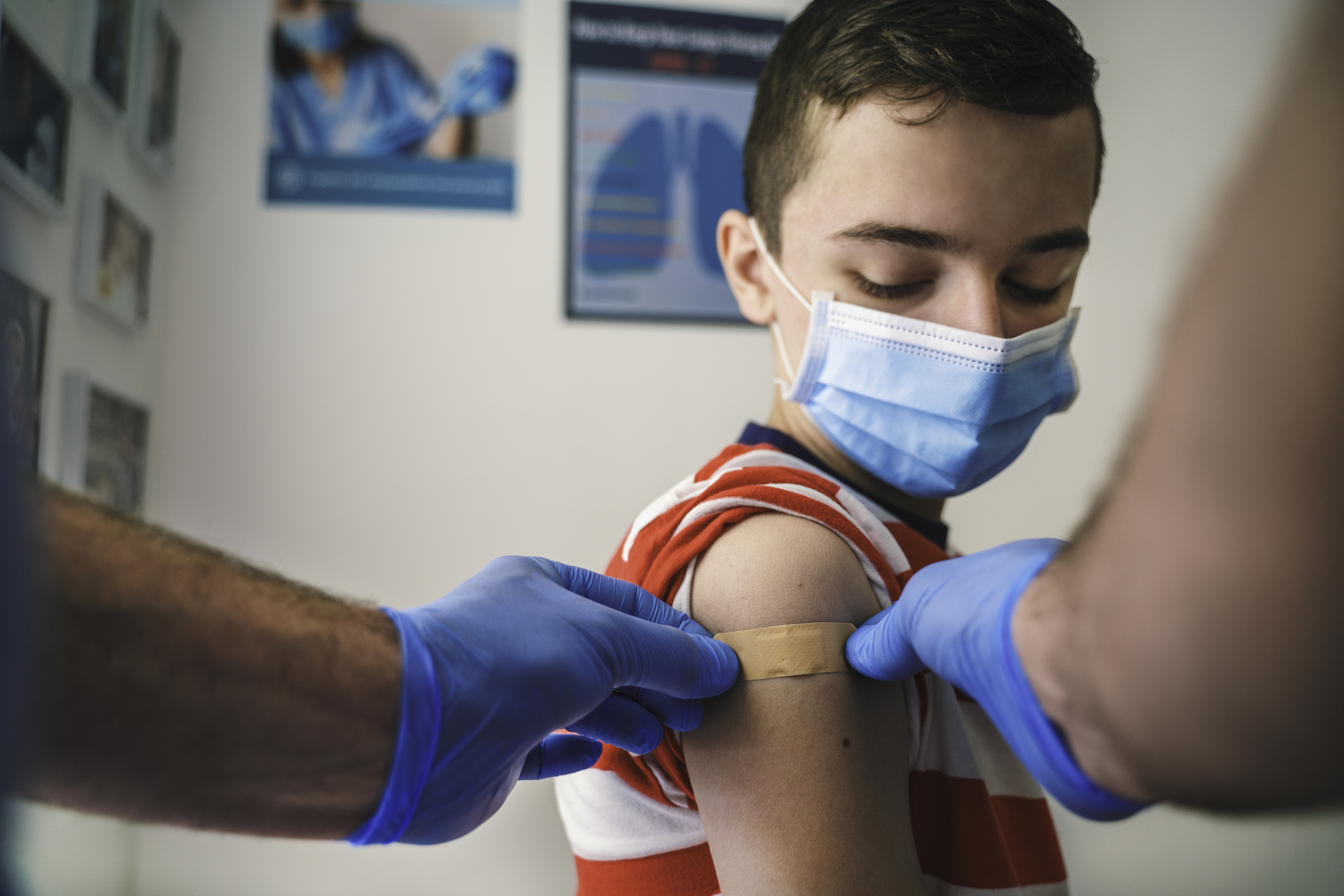 A child receives a bandage after receiving a shot.
