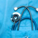 Picture of a doctor’s uniform shirt pocket with a stethoscope in the pocket.