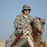Elizabeth Nagle, a licensed practical nurse at Penn State Health Medical Group, Community Practice Division, rides a camel in Kuwait during Operation Iraqi Freedom, where she provided medical support to the Oklahoma National Guard during deployment to Iraq.
