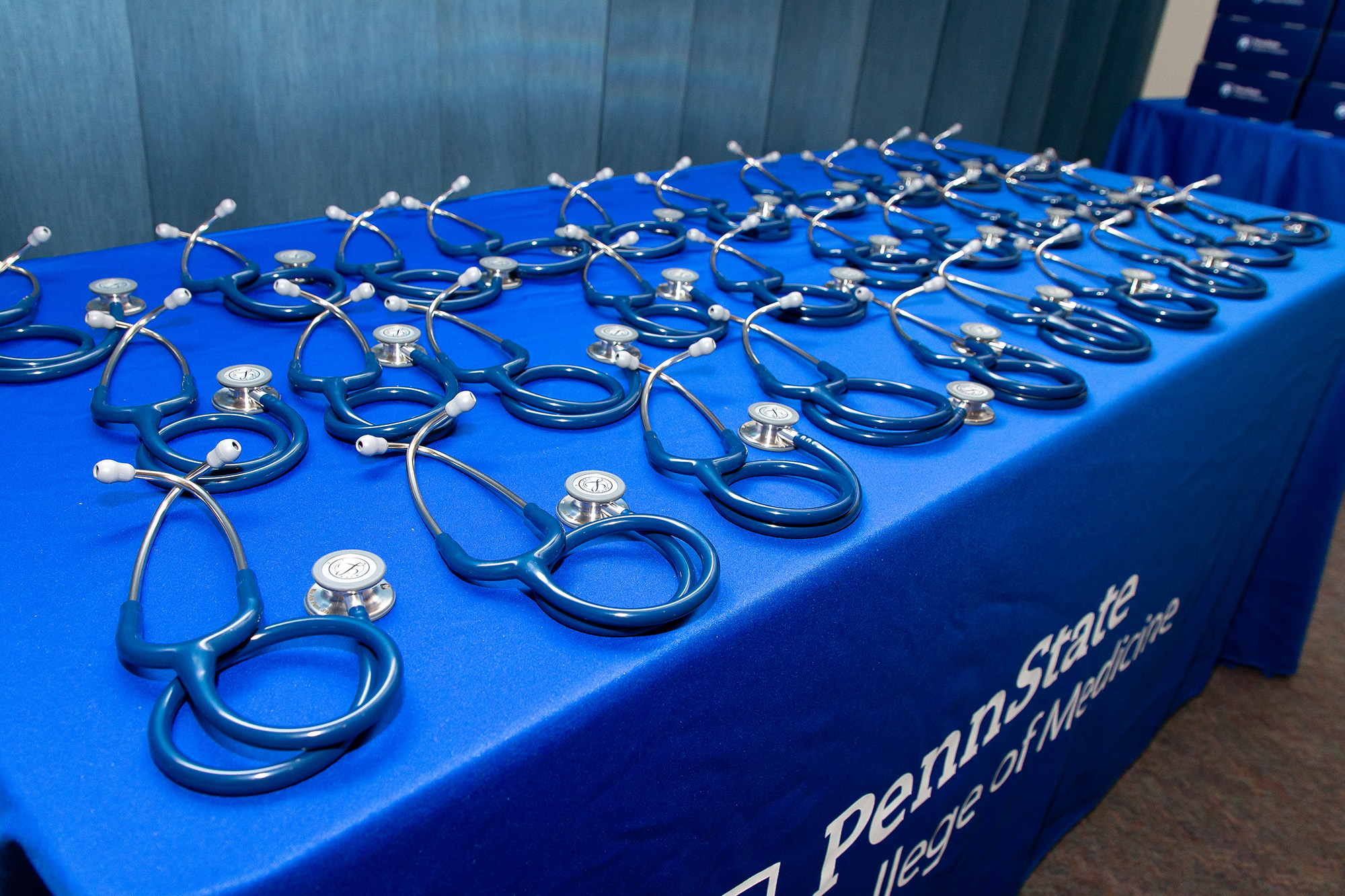 Stethoscopes on a table with a tablecloth that says Penn State College of Medicine