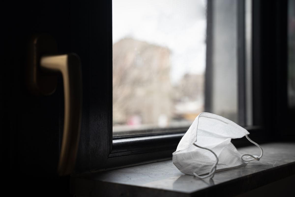 Surgical mask setting on a table by a window.