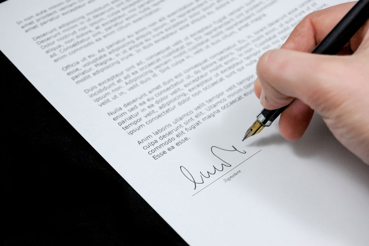 Person signing a paper document