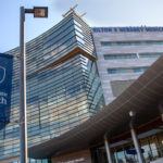The front of a hospital with a banner in the foreground that says, "Penn State Health"
