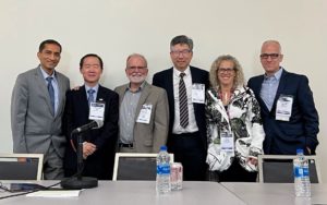 Dr. Matthew Moyer, far right, stands beside a table and chairs, with five other people who attended the Digestive Disease Week conference in San Diego, California. 