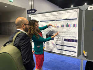 Dr. Raz Abdulqadir, gastroenterology fellow, stands with another individual in front of a research poster on epithelial junctions and barrier function during the Digestive Disease Week conference.