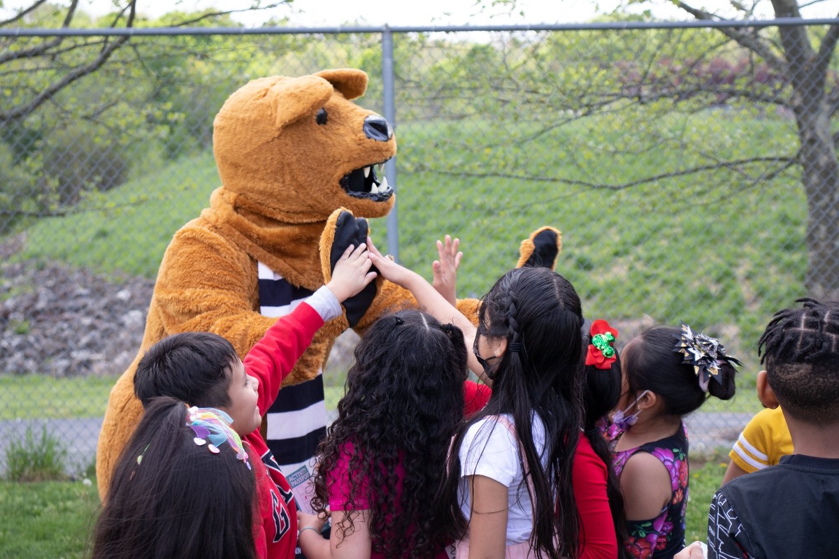 The Nittany Lion cheers on children.