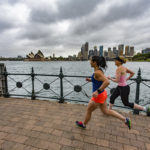 Two women jog along the Sydney Harbour.