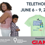 Two children - a boy and a girl - stand back to back next to text reading "TELETHON JUNE 6-9, 2022."