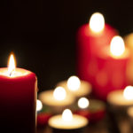 Group of lit candles against dark background