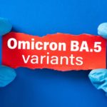 Doctor's hands in blue gloves hold writing on torn paper that says “Omicron BA.5 variants.”
