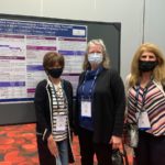Rebecca Bascom and two colleagues pose for a photo in front of a poster board. They are wearing masks.