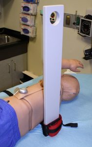 A custom designed chest compression board is placed beside a pediatric mannikin in the Clinical Simulation Center.
