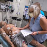 Dr. Susan Promes searches for various pieces of medical equipment on a mannikin in the Simulation Center.