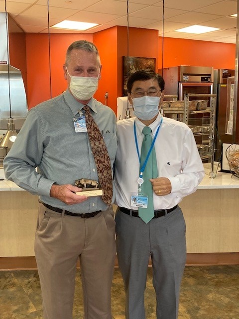 Gregg Atland, left, and Dr. Thomas Ma stand side by side wearing surgical masks