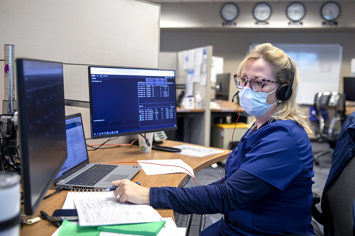 A nurse in a virtual intensive care unit looks at monitors that show patient conditions.