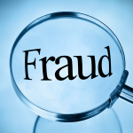 Magnifying glass being held over the word “fraud.”