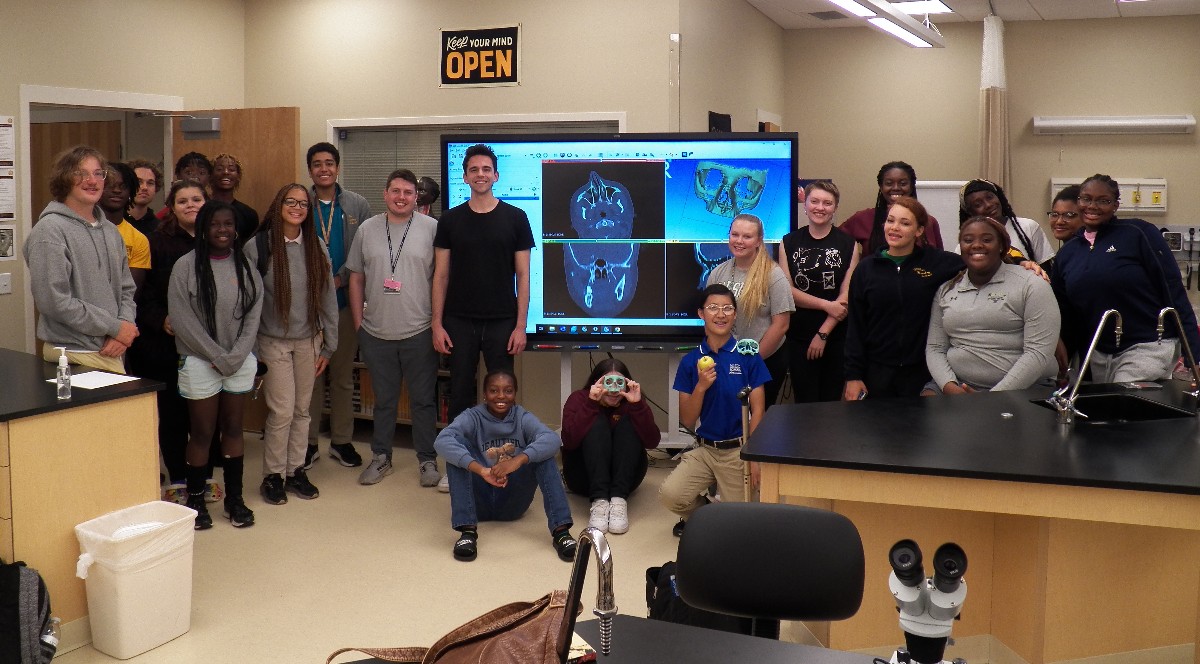 Marc Levine, Thomas Brouse and Milton Hershey School students pose for a photo while holding facial bone they 3D-printed.